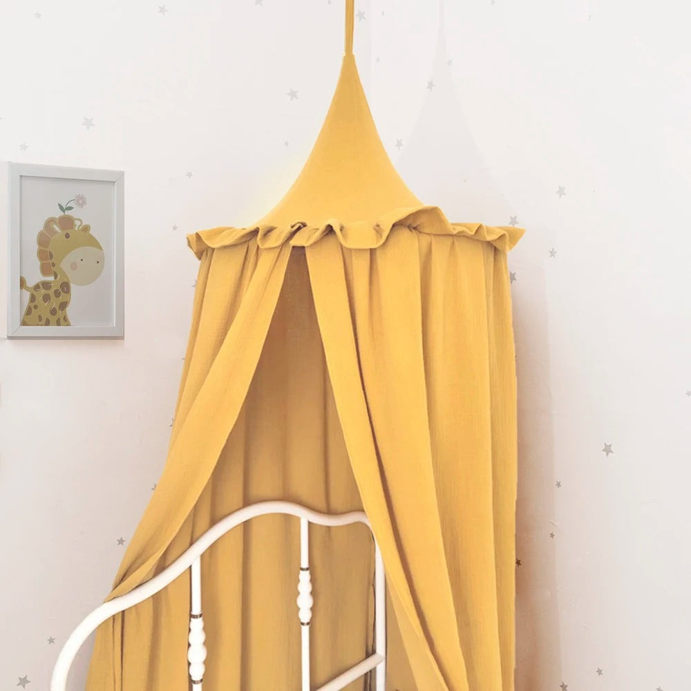 Ciel de lit royal jaune accroché au dessus d'un lit enfant